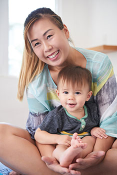 Mom holding her adorable toddler son on her lap