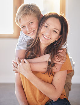 Smiling mom and son hugging each other