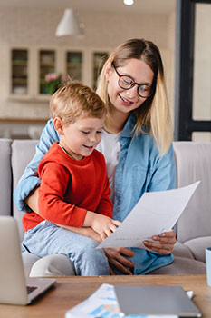 Mom holding her infant son and looking at a universal life insurance illustration