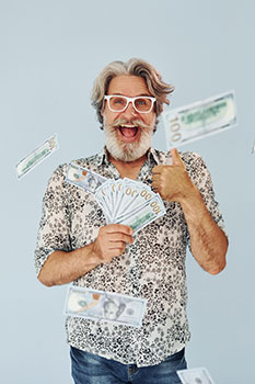 Man holding a fan of hundred dollar bills and smiling
