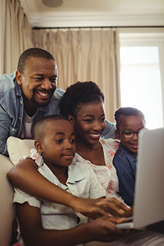 Happy family using the laptop together to look up universal life insurance quotes