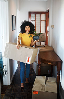 Woman carrying boxes into her new apartment