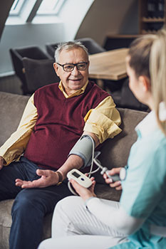 Senior man with an in-home doctor checking his blood pressure